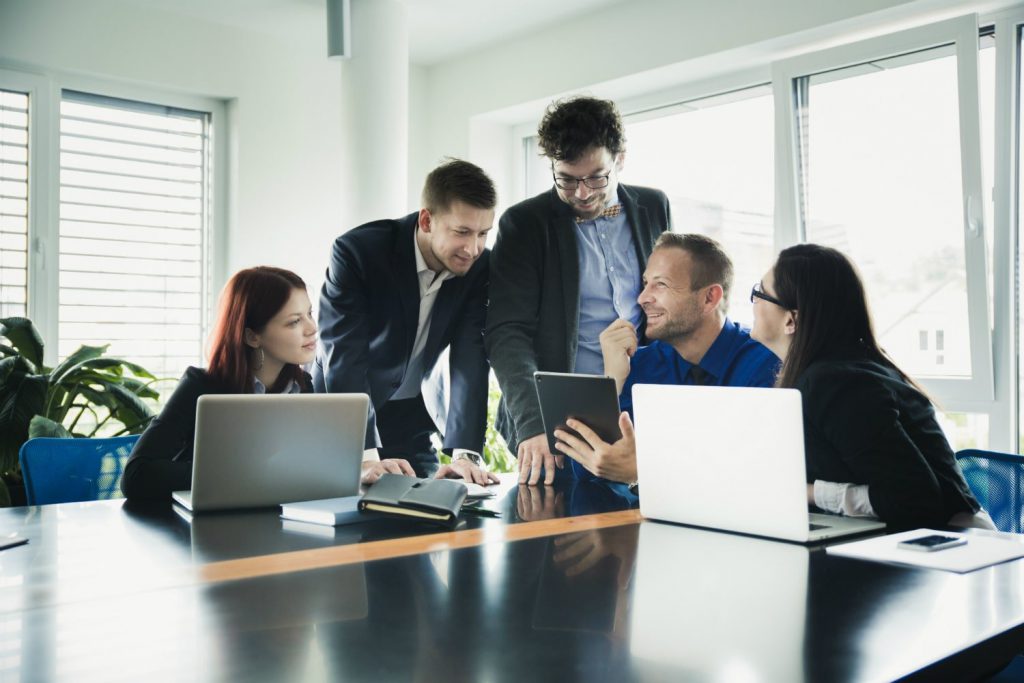 Pessoas no escritório analisando um sistema ERP no computador.